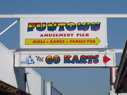 a boardwalk sign advertising for the Funtown Pier